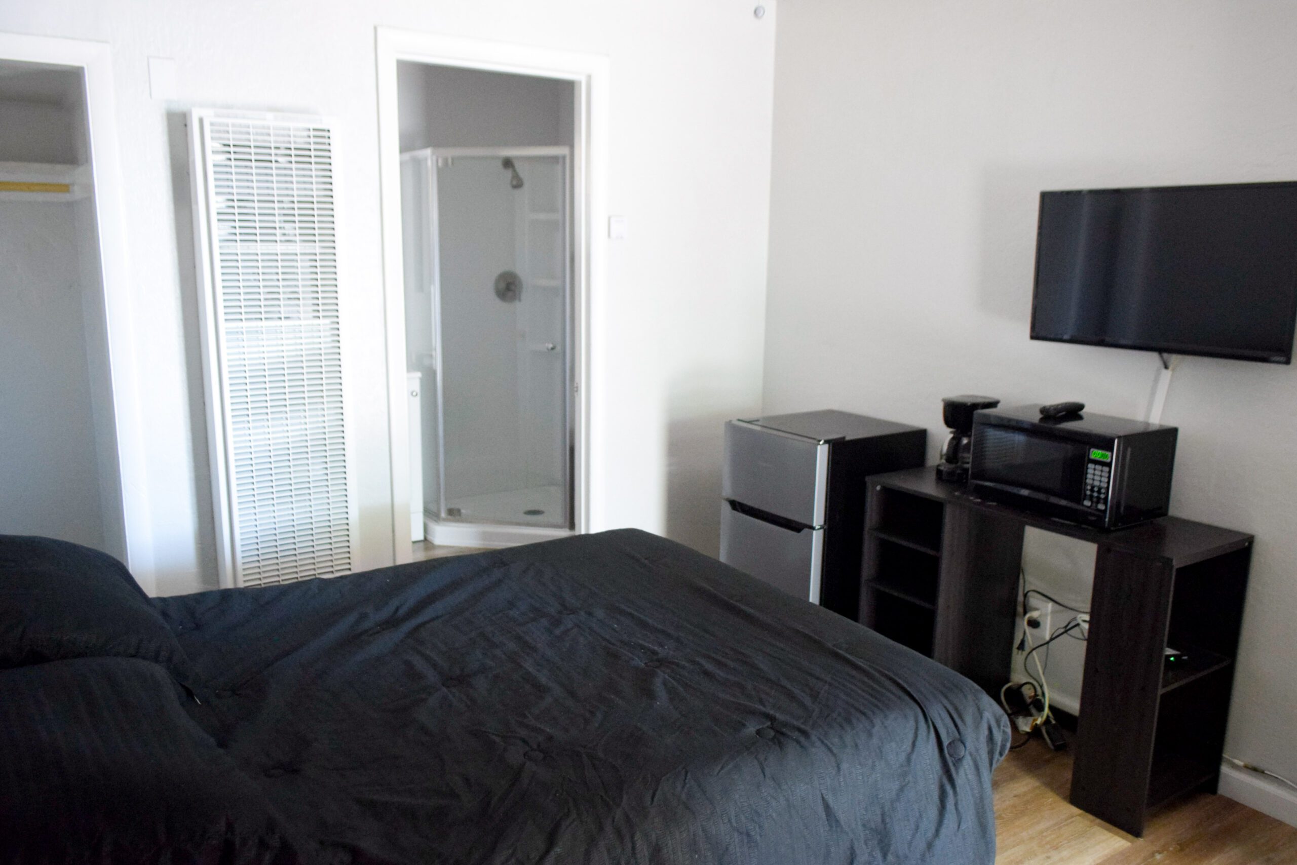 Bedroom with oven, refrigerator and TV